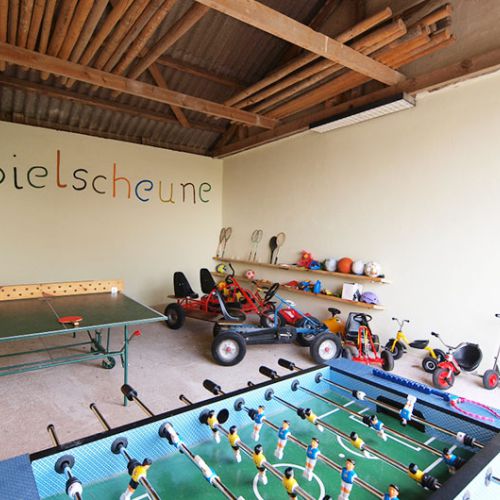 Spielscheune mit vielen Spielsachen und Fahrzeugen für Kinder