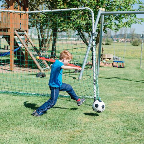 Ein Junge spielt Fußball auf der Wiese